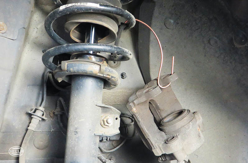 Tie up the brake caliper on the suspension strut using a suitable hook